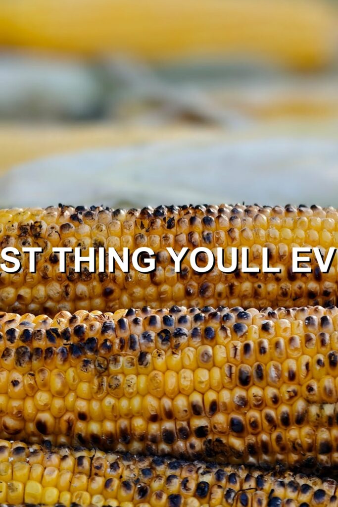 Crispy golden grilled corn atop a bed of perfectly cooked charcoal, serving up a warm and inviting summertime treat.