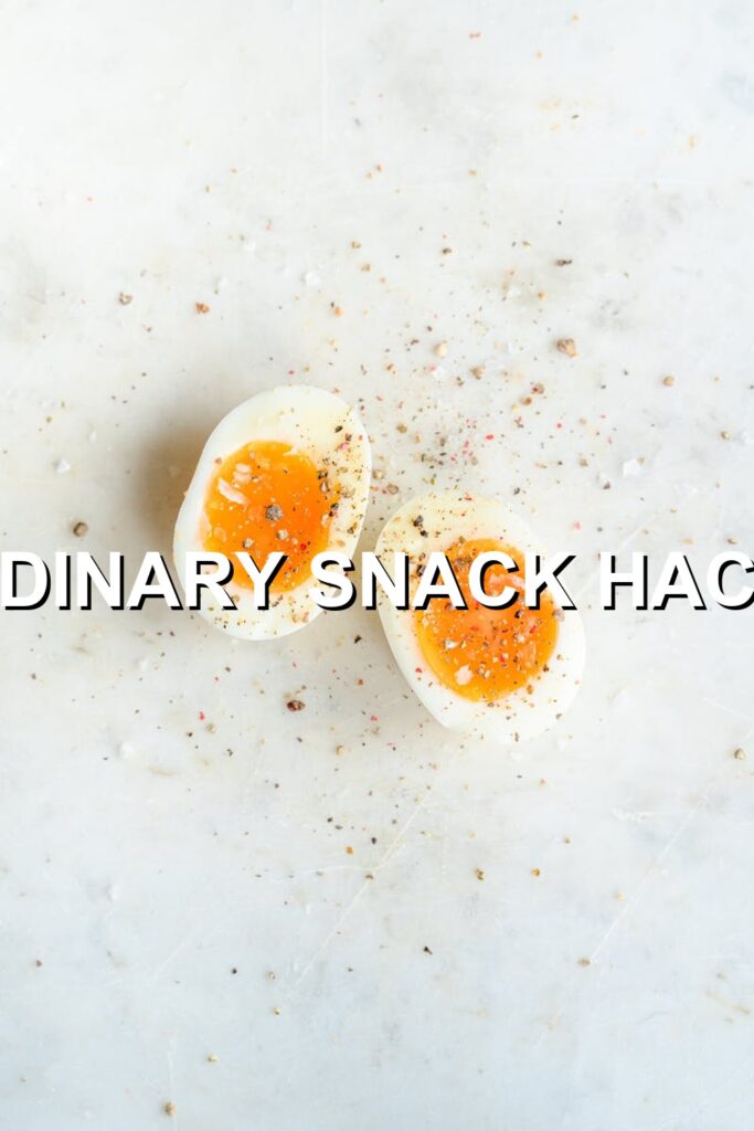 Delightful deviled eggs with a vibrant yellow yolk, speckled with black pepper, nestled in a white bowl on a marble counter.