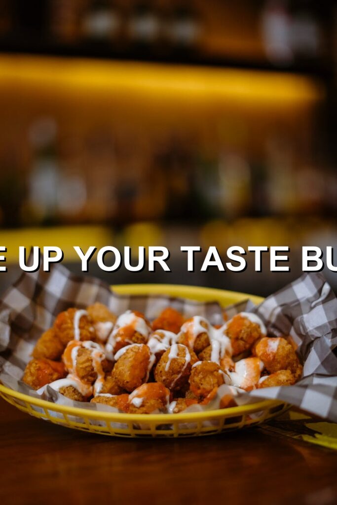 Savory chicken wings bathed in golden brown sauce, served in a vibrant yellow basket with white paper doily atop, offering an irresistible feast for your taste buds.